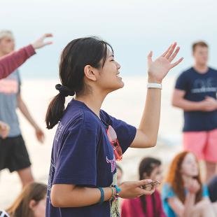 一名女学生举着双臂唱歌