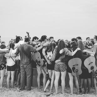 一群学生在海滩上祈祷