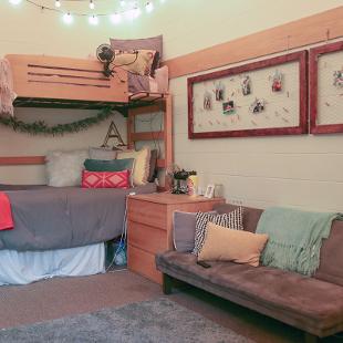 Two bed are arranged in a bunk bed style in a student room.