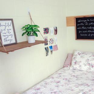 A bed and personal decorating touches added in a student room.