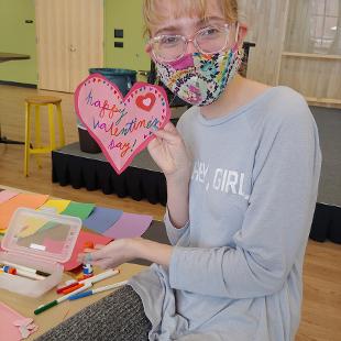 A student holding up a valentine