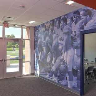 The hallway leading out to the football field has a huge photo of the current football team cheering.