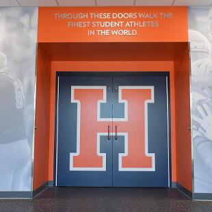 The locker room entry doors have a huge H branded for athletes and above the doorway it states 