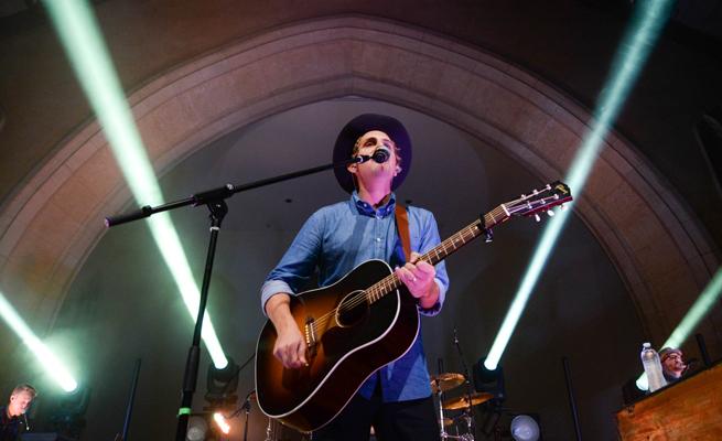 Ben Rector performing with a guitar in Dimnent Chapel