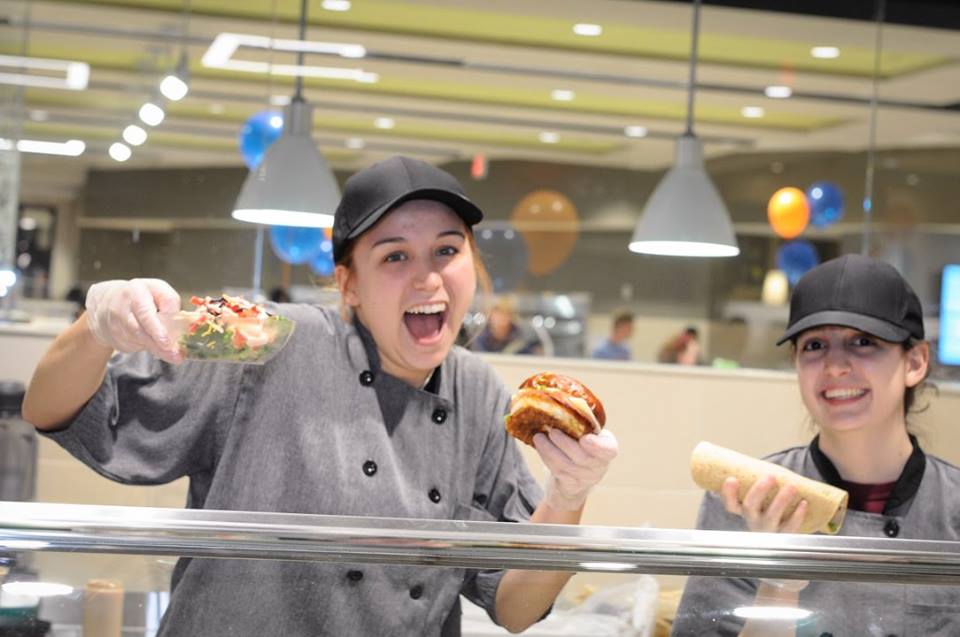 Student workers smiling with food